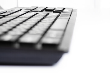 Computer keyboard on a white background. Closeup. Selective focus. Side view