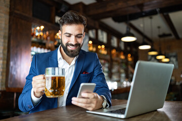 Portrait of a successful business man sitting at the cafe working on a laptop.