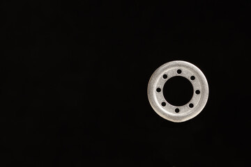 washer with holes for screws under side lighting on a black background