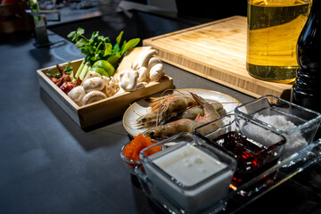 Cooking ingredient, lime, mushroom, shallot, lemon grass, onion, chilli, tobiko, bergamot, shrimp and cheese in wood box plate. They are ready for meal cooking.
