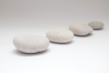 Fototapeta na wymiar a row of smooth pebbles on white background