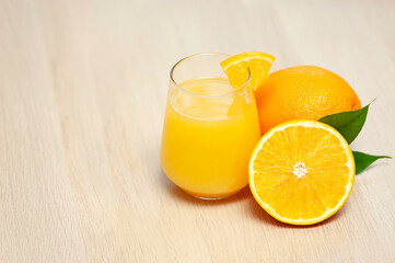 Orange fruit slices and a glass of juice on the table, copy space