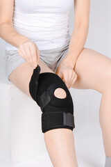 Knee Support Brace on leg isolated on white background. Elastic orthopedic orthosis. Anatomic...