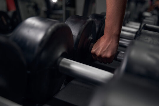 Focused photo on female hand that taking weights