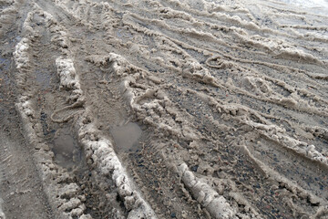Tyre tracks on dirty wet snow road.