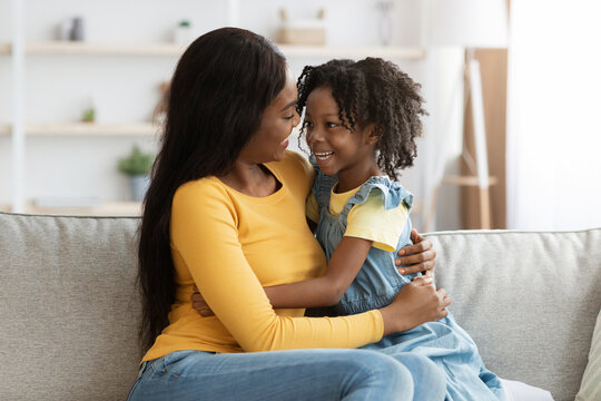 Portrait Of Cheerful Young Black Woman Embracing With Her Daughter At Home