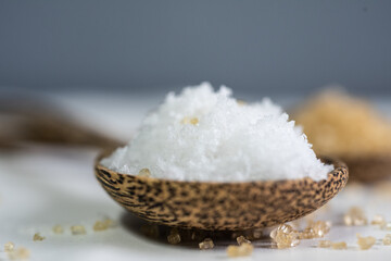 White salt on spoon wood.