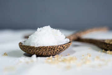 White salt on spoon wood.