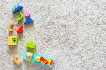Colorful wooden pyramid with geometric details on a white cotton carpet. Eco friendly, plastic free...