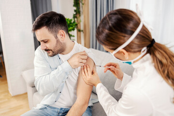 A scared man getting covid 19 vaccine at his home.