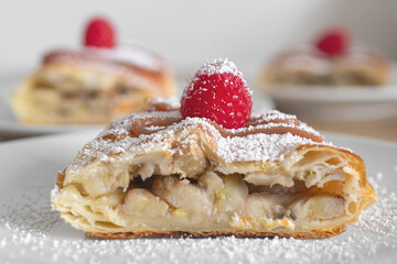 Apple quiche with powdered sugar and garnished with raspberries