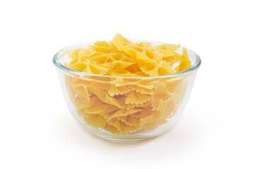Uncooked bow-tie pasta in glass bowl on white background