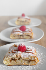 Apple quiche with powdered sugar and garnished with raspberries