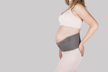 Pregnant woman belly in prenatal pregnancy maternity belt. Orthopedic abdominal support waist,...
