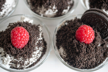 weet dessert with raspberries, mascarpone cream and cream, sprinkled with chocolate chip cookies