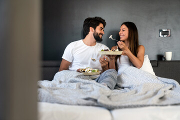 Romantic happy couple having breakfast in bed