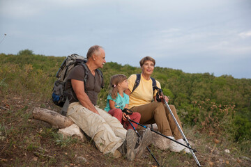 grandparents and grandchild with backpack hiking in outdoor. Digital detox. Staycations. ...