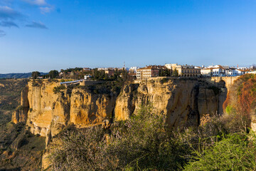 view of the old town of Ronda and the Puente Nuevo over El Tajo Gorge in warm evening light