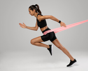 Sportswoman exercising with resistance band. Female with working out with elastic band on white background