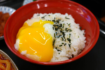 Egg yolks burst on top of the rice and spread out.