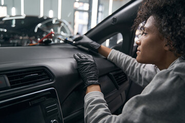 Technician seated in car examining windshield repair device