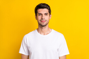 Photo of charming confident positive man look camera wear white t-shirt isolated yellow color...