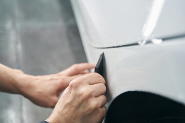 Worker hands polishing exterior surface of auto body panel