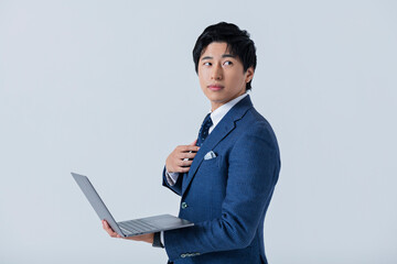 ノートパソコンを操作する20代ビジネスマン