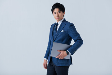 ノートパソコンを持った20代ビジネスマン