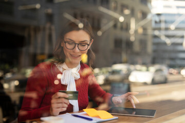 Happy woman using credit card to shopping online with tablet. Beautiful young woman drinking coffee...