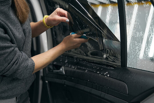 Service Station Worker Fixing Protective Film On Car Windo