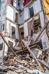 building in ruin with a collapsed wall and visible damaged apartments