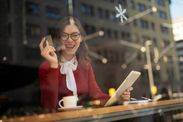 Happy woman using credit card to shopping online with tablet. Beautiful young woman drinking coffee in cafe..