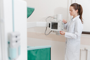 Hospital Radiology Room. Xray machine for fluorography. Doctor radiologist in gown adjusting the...