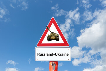 Warnschild Russland Ukraine mit Panzer und blauen Himmel