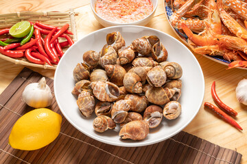 Seafood dish, steamed and cooked blue crab and areola babylon or spotted babylon , served with Thai spicy and sour seafood dipping sauce.