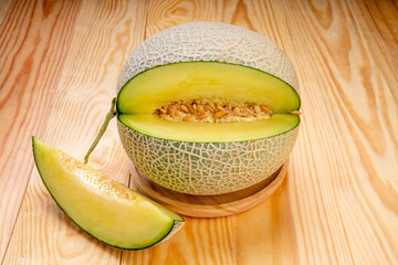 Green melon with slices on wooden background, Cantaloupe Melon fruit on wooden table.