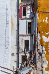 building in ruin with a collapsed wall and visible damaged apartments