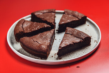 Chocolate Flourless Cake on red background. Soft chocolate gateau or Brownie cake. Selective focus - 488740514