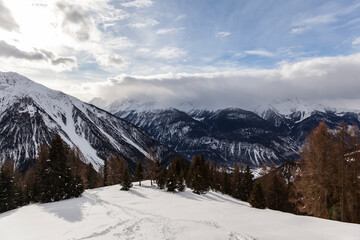 Winter scenery in the European Alps, Graubuenden, Switzerland, with snow-covered mountains, clouds, and sky