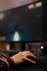 Close up of hands using mouse to play video games on computer. Gamer playing digital game with mouse and pad in front of monitor to have fun. Player using online gaming equipment