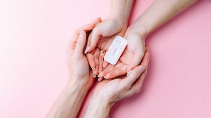Pregnancy test kit. Female hand hold positive pregnant test with silk ribbon on pink banner background. Medical healthcare gynecological, pregnancy fertility maternity people concept. © Maksym
