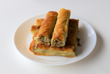 pie with ground beef filling, rolls of puff pastry with meat on plate