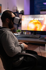 Man with vr glasses playing video games with joystick on computer. Person losing game with virtual reality goggles and joystick in front of monitor. Player with online video game.