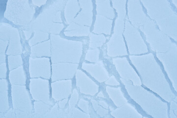 Abstract winter background texture of cracked snow.