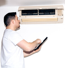 The insurance worker is assessing the home's air conditioning system.