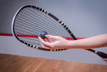 Image of a woman's hand with a squash racket. Sports concept