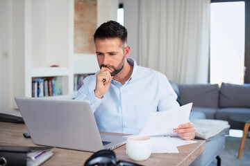 Businessman using laptop while working from home