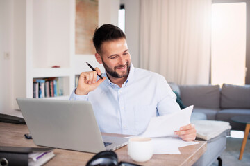 Obraz premium Businessman using laptop while working from home