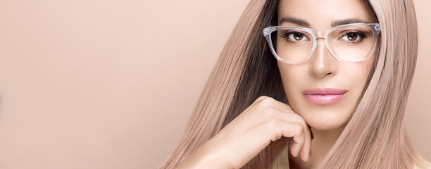 Women eyewear. Close up of beautiful woman face in fashionable clear glasses posing in studio....